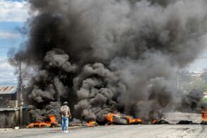 a man standing in front of a large fire